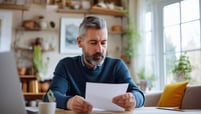 man looking at letter to buy home