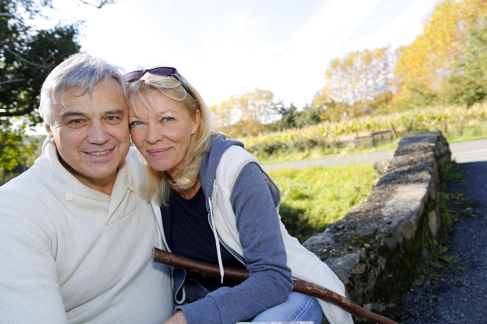 Closeup of happy senior couple sitting by river