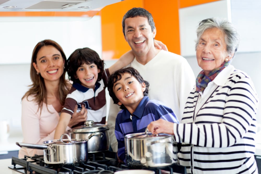 Happy Latin family cooking together at home