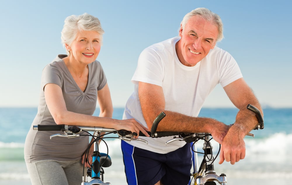 Retired couple with their bikes on the beach-1
