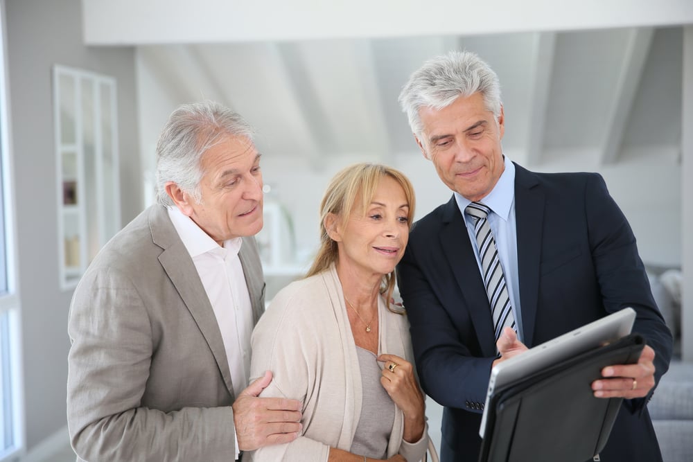 Senior couple with real-estate agent visiting house for sale