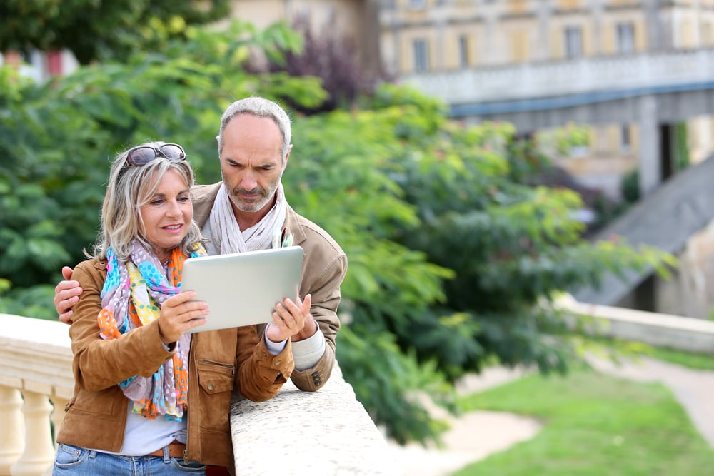 Senior tourists looking for information on tablet